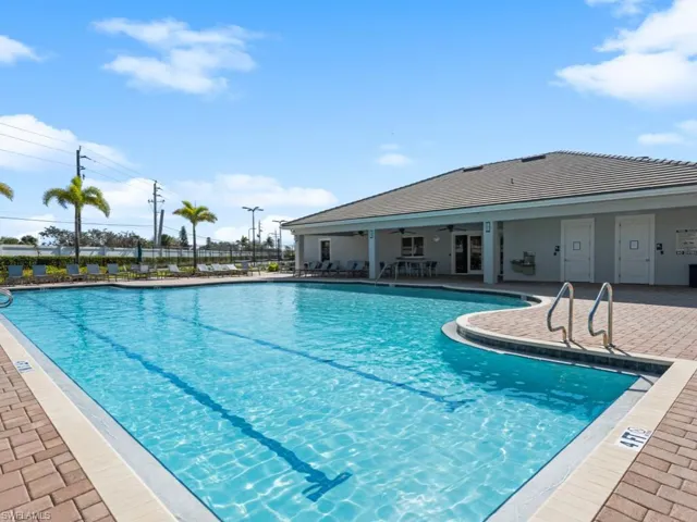 Community pool with a patio, fence, and a ceiling fan