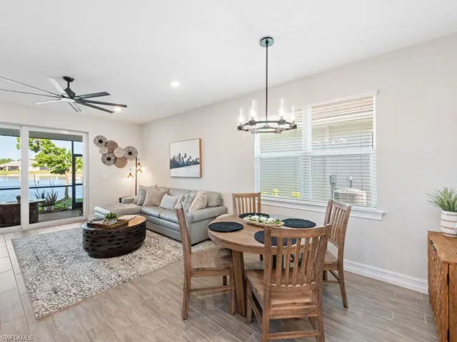 Dining room featuring light wood-type flooring, ceiling fan with notable chandelier, baseboards, and recessed lighting