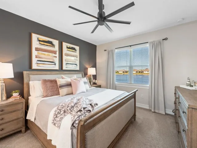 Bedroom featuring baseboards, a ceiling fan, and light carpet