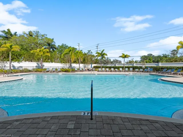 Community pool featuring a patio area and fence