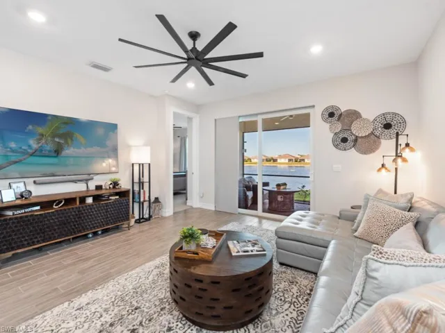 Living area with recessed lighting, visible vents, ceiling fan, and wood finished floors