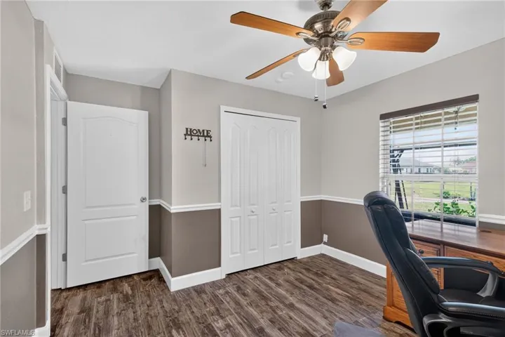 Interior room featuring wood-finish flooring and two-tone painted walls with chair rail molding