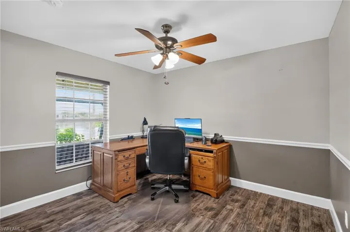 Interior room featuring wood-finish flooring and two-tone painted walls with chair rail molding