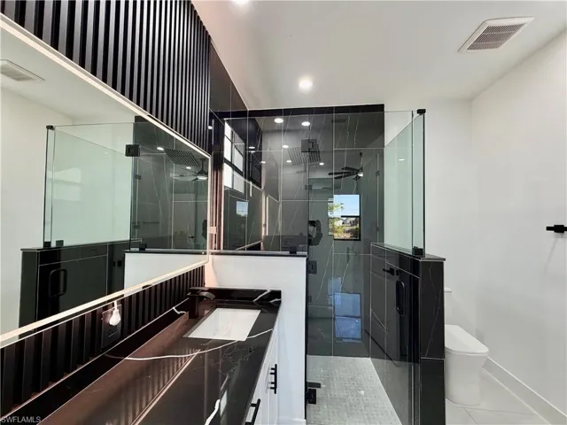 Bathroom with vanity, a stall shower, recessed lighting, and light tile patterned flooring