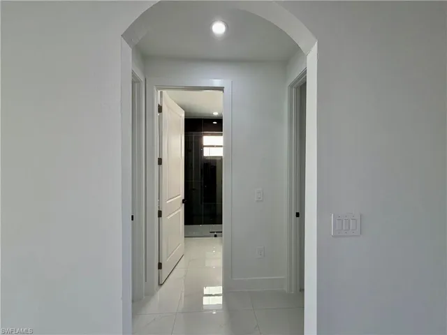 Hallway featuring arched walkways and recessed lighting