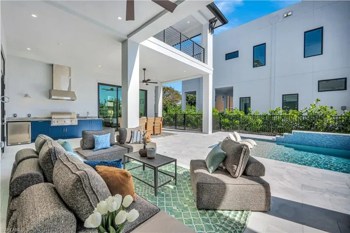 Patio / terrace with a ceiling fan, an outdoor kitchen and area to lounge, a patio, and an outdoor pool