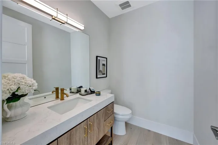 Half bathroom with vanity and light wood finished floors