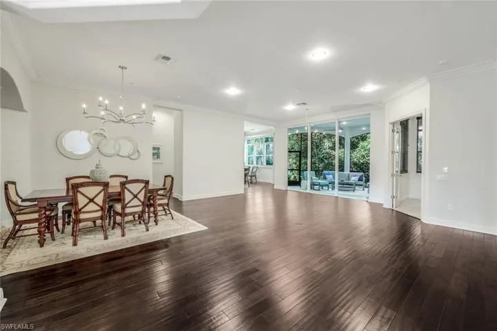 Dining space with crown molding, an inviting chandelier, and dark hardwood / wood-style flooring