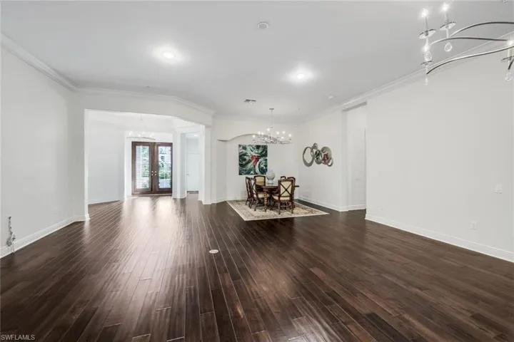 Living room with crown molding, french doors, and dark hardwood / wood-style flooring