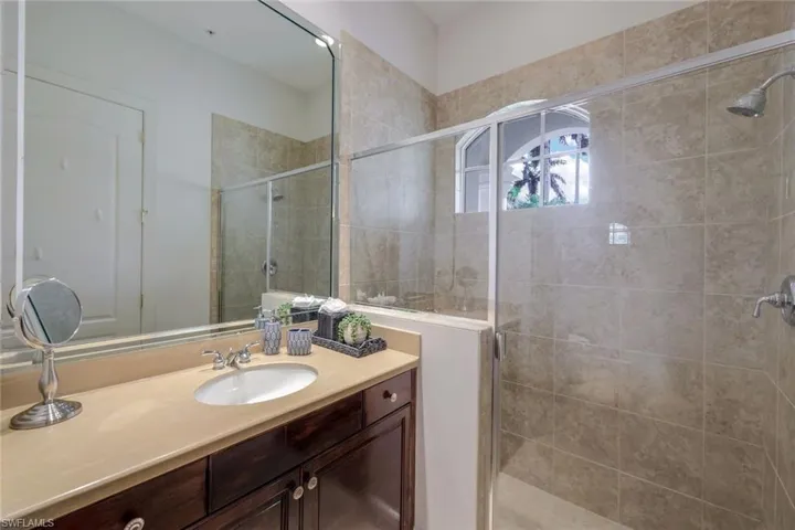 Bathroom featuring a shower with door and vanity