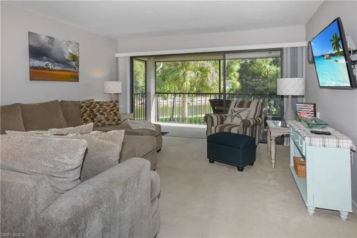 Living room with light colored carpet and healthy amount of natural light