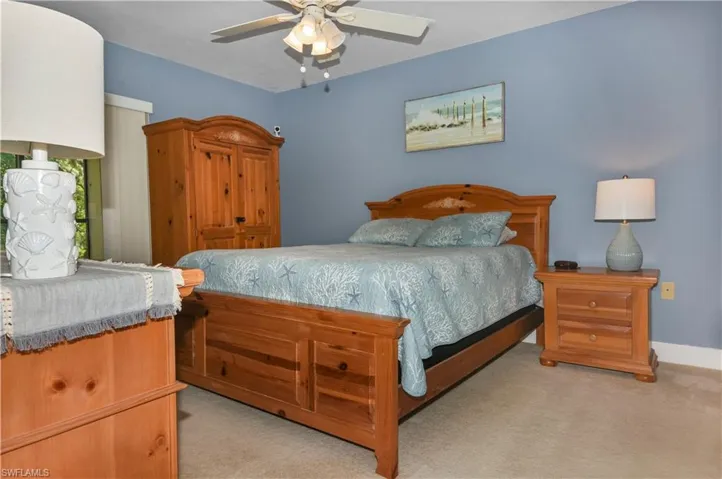 Bedroom with light colored carpet and a ceiling fan