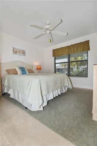 Bedroom with light carpet and a ceiling fan