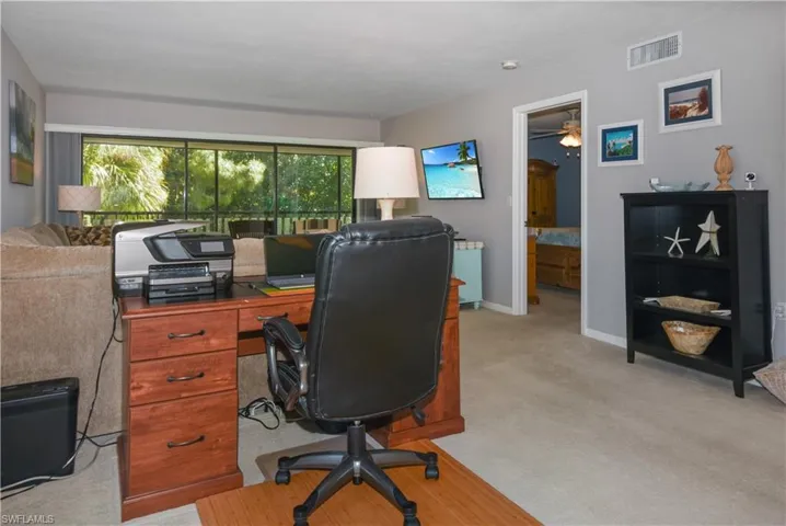 Office area with light colored carpet and ceiling fan