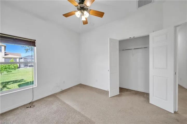 Unfurnished bedroom with light carpet, a ceiling fan, and a closet