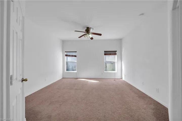 Empty room featuring carpet floors and a ceiling fan