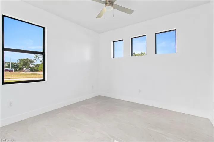 Empty room with baseboards and a ceiling fan
