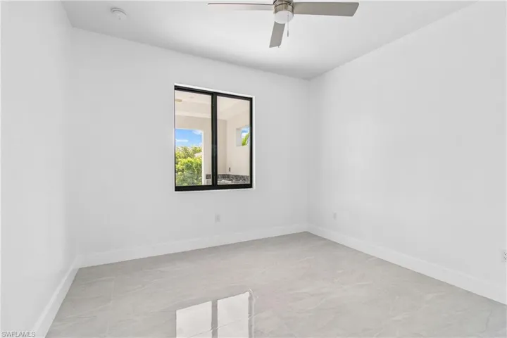 Empty room with baseboards and a ceiling fan