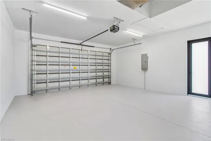 Garage featuring electric panel and a garage door opener