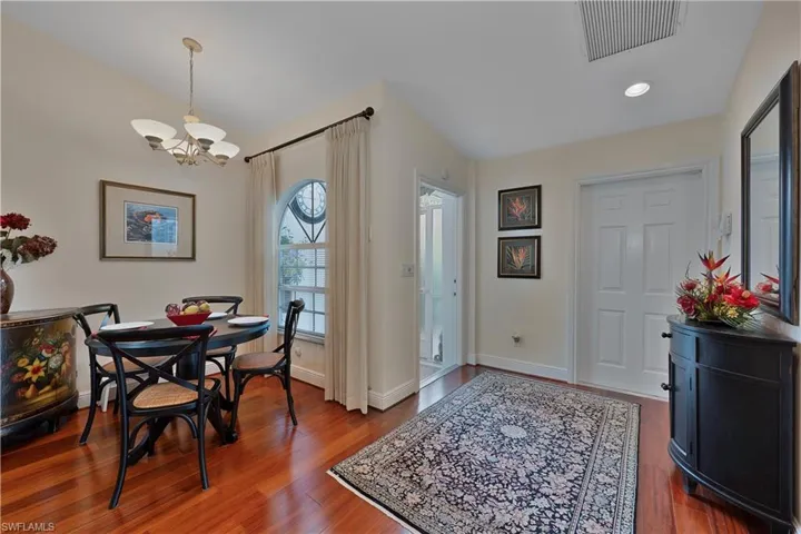Dining room with  chandelier, wood finished floors, and recessed lighting