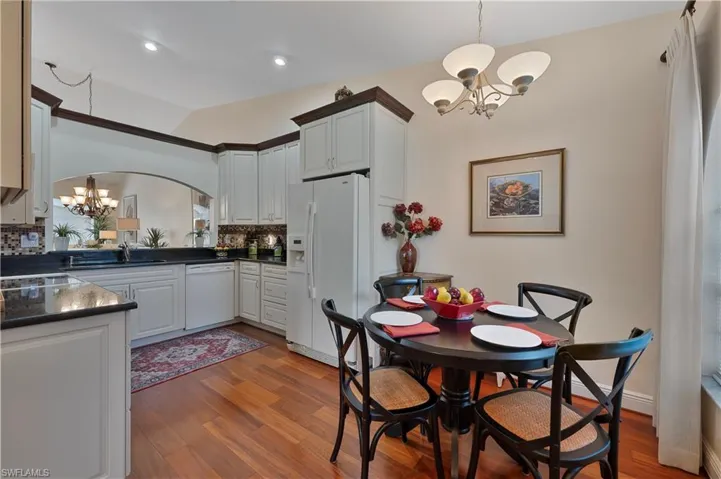 Eat in Kitchen with a chandelier, wood floors, and recessed lighting