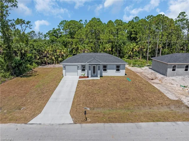 View of front of property featuring a garage and a front lawn