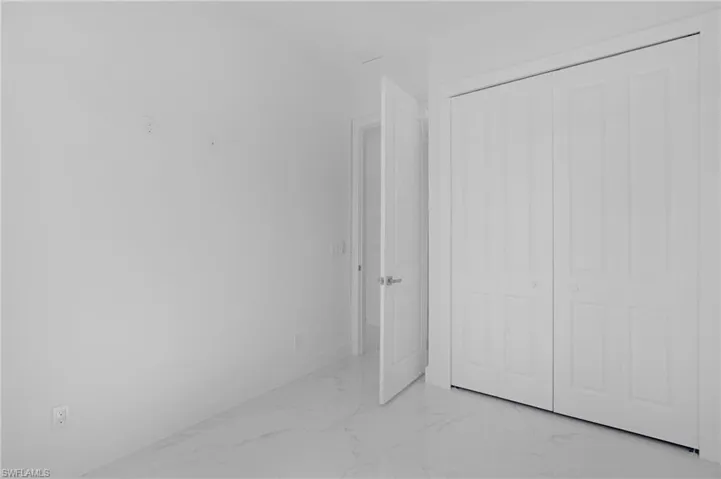 Unfurnished bedroom featuring tile flooring and a closet