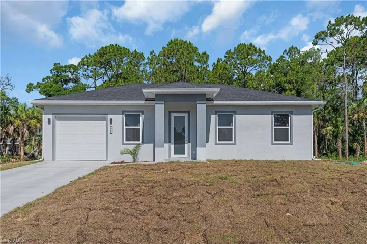View of front facade with a garage and a front lawn
