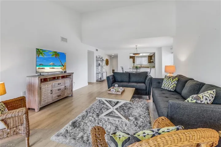 Living room featuring light wood-type flooring and a high ceiling