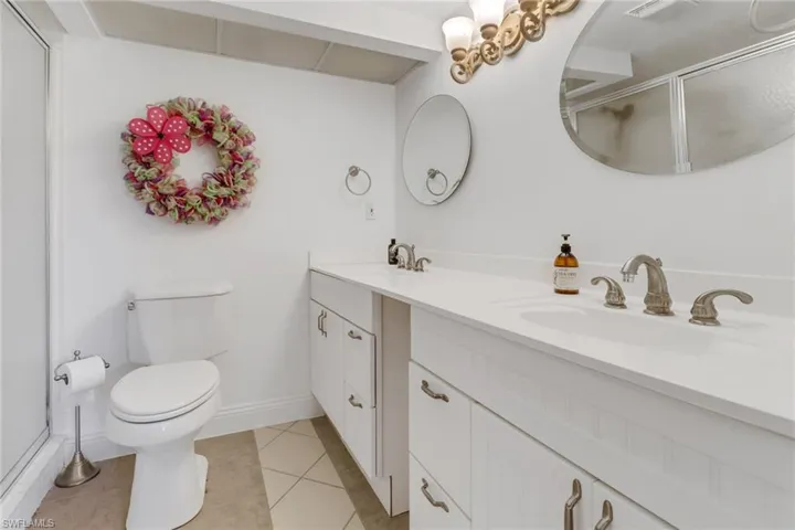 Bathroom with vanity, toilet, a shower with door, and tile patterned floors