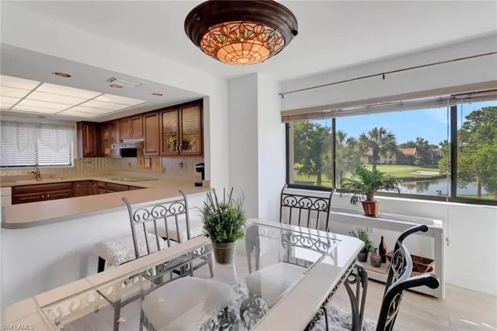 Dining space with light hardwood / wood-style floors, a water view, and plenty of natural light