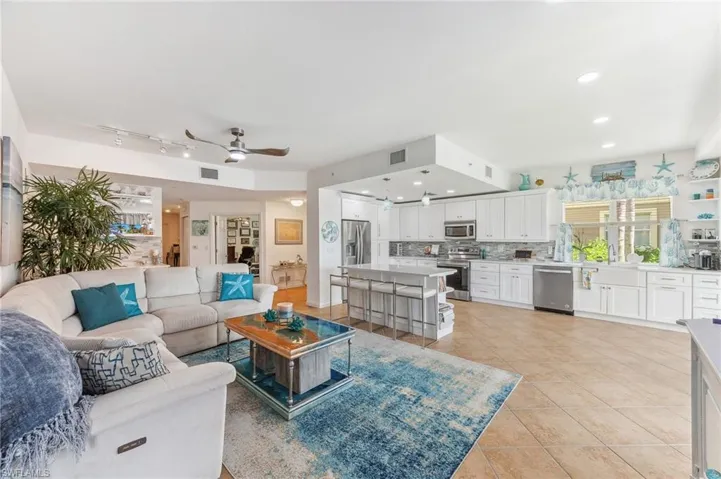 Living room with sink, light tile patterned floors, and ceiling fan