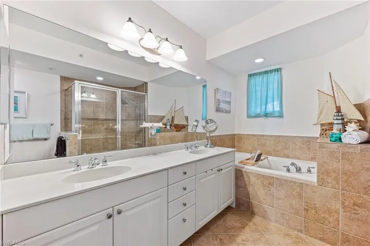 Bathroom with vanity, tile patterned floors, and independent shower and bath