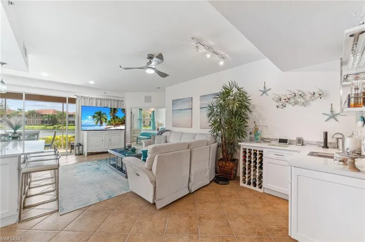 Living room featuring sink, ceiling fan, and light tile patterned flooring
