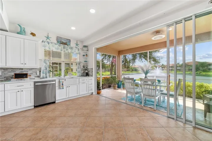 Kitchen featuring dishwasher, white cabinetry, decorative backsplash, and light tile patterned floors