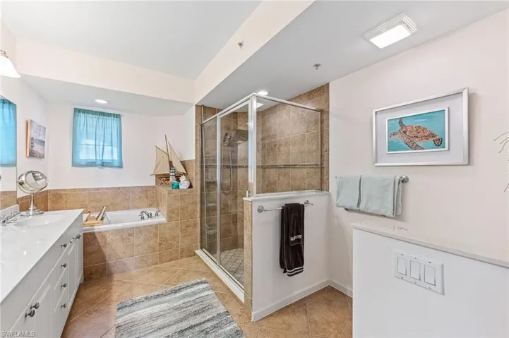 Bathroom featuring vanity, tile patterned flooring, and plus walk in shower