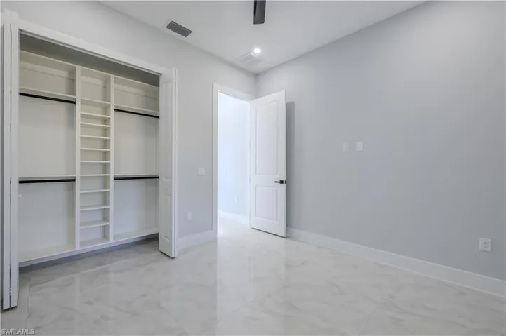 Unfurnished bedroom with light marble finish floors, a closet, ceiling fan, and recessed lighting