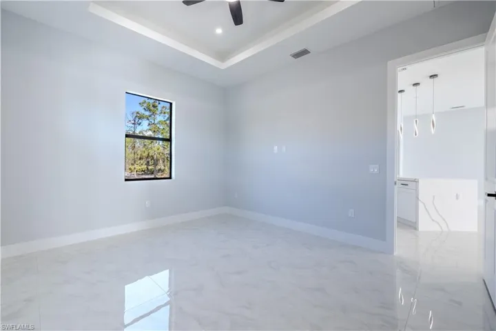 Unfurnished room with a tray ceiling, recessed lighting, and ceiling fan