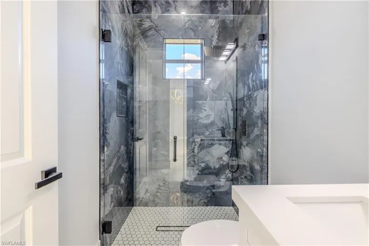 Bathroom featuring vanity and a marble finish shower