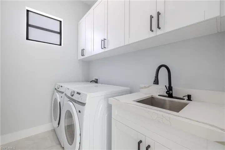 Laundry room with cabinet space and washer and clothes dryer