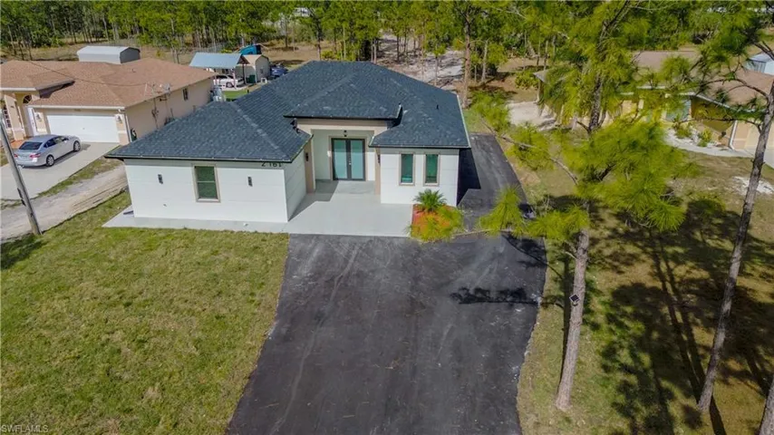 View of front of home featuring driveway, a front lawn, and stucco siding