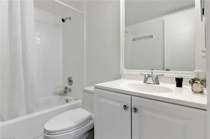 Full bathroom featuring shower / bath combination with curtain, vanity, and toilet