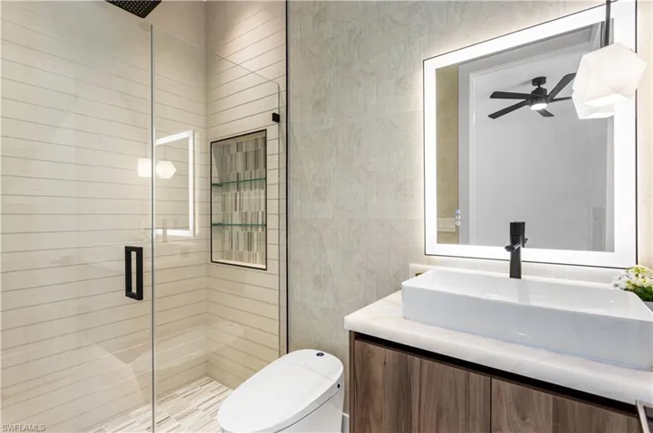 2nd Master Bathroom with floating custom cabinetry, bidet toilet, lighted mirror & vessel sink