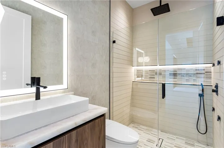 3rd Guest Bathroom with floating custom cabinetry, bidet toilet, lighted mirror, vessel sink, rainfall shower, four jets and hand-held shower heads!