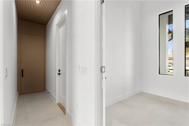 LAUNDRY is CONCEALED by ACOUSTIC PANELING door & hallway