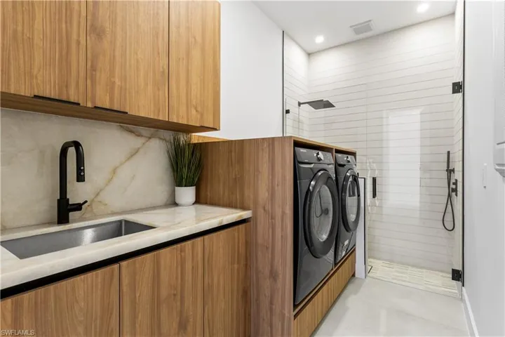 It features CLEANING STATION, SAMSUNG washer & dryer, laundry tub w/ full backsplash & storage cabinets