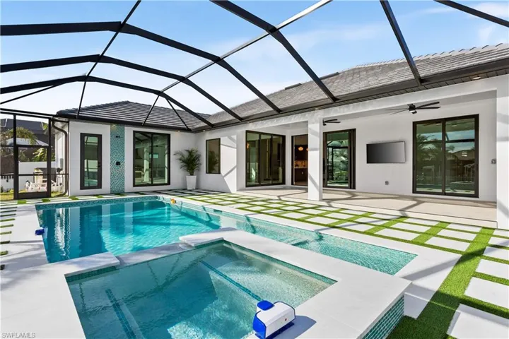 STEP OUTSIDE to YOUR WATERFRONT OASIS, featuring OVERSIZED HEATED SALTWATER POOL & SPA, surrounded by ARTIFICIAL GRASS, PAVED STONES & EXUBERANT LANDSCAPING & FENCED YARD & WATERFRONT