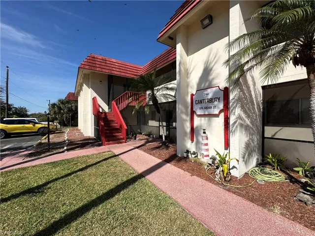 View of home's exterior featuring stairs, a tile roof, and stucco siding