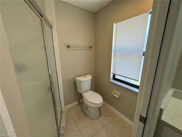 Master Bathroom featuring vanity, toilet, an enclosed shower, and tile patterned flooring