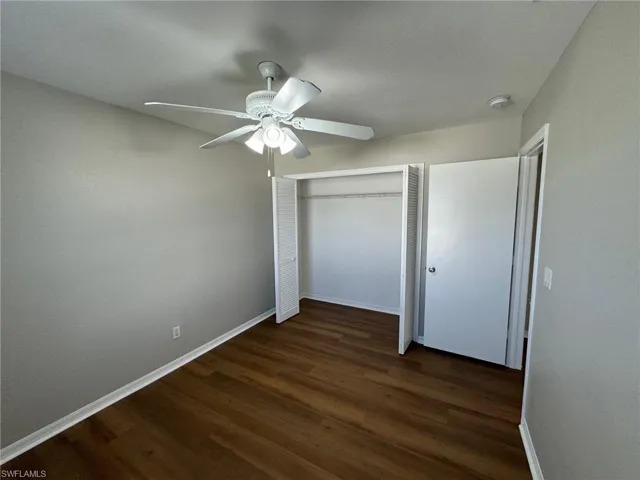 Guest bedroom 2 featuring dark hardwood / wood-style floors, ceiling fan, and a closet